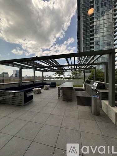 A rooftop patio with a metal pergola and benches.