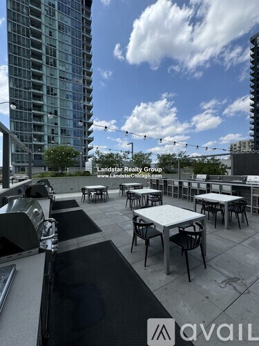 A rooftop patio with tables and chairs overlooking a cityscape.