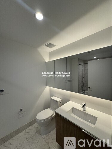 A white toilet sits next to a sink in a modern bathroom.