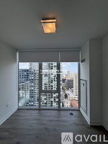 A room with a large window overlooking a cityscape.