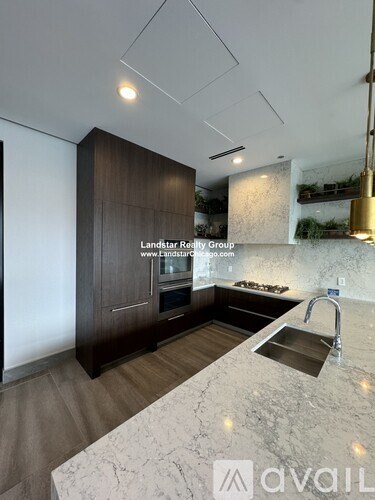 A modern kitchen with a marble countertop and a sink.