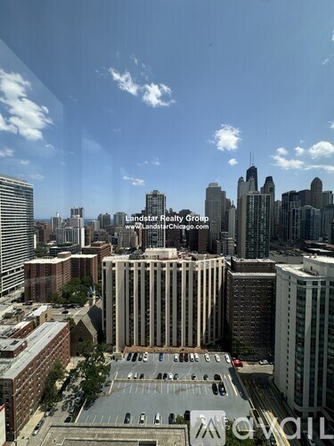 A cityscape with a building in the foreground and the skyline of a city in the background.
