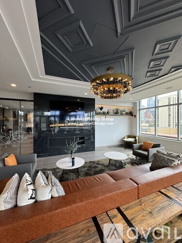 A modern living room with a wooden floor and a large chandelier.