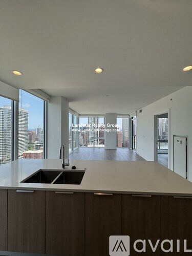 A kitchen area with a sink and a counter with a logo on it.