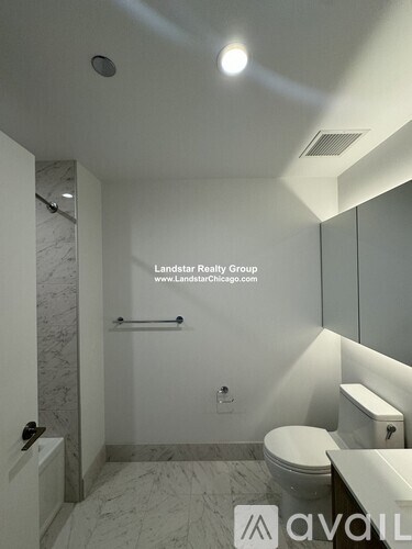 A bathroom with a toilet, sink, and mirror.