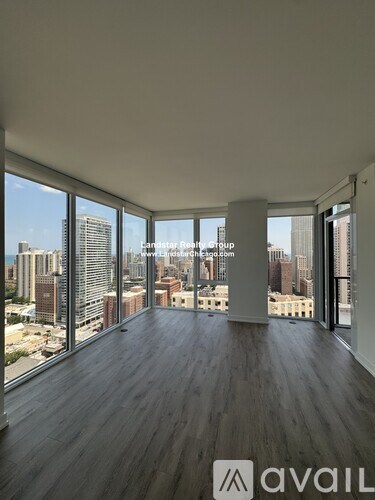 A room with wooden floors and large windows overlooking a cityscape.