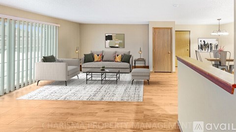 A living room with a grey sofa and a rug.