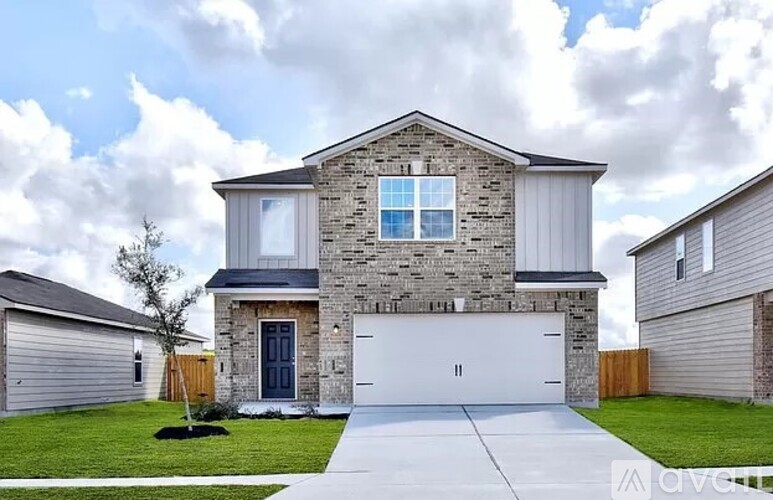 A modern house with a stone facade and two garages.