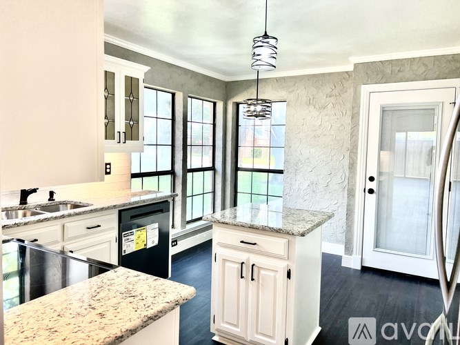 A kitchen with granite countertops and a stainless steel dishwasher.