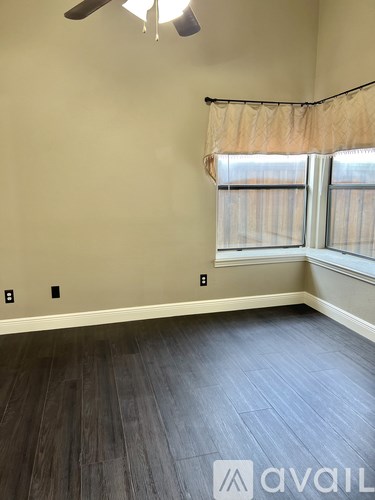 A room with a window and a ceiling fan.