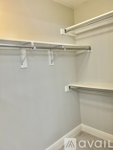 A wall-mounted shelf with two shelves is installed in a room.