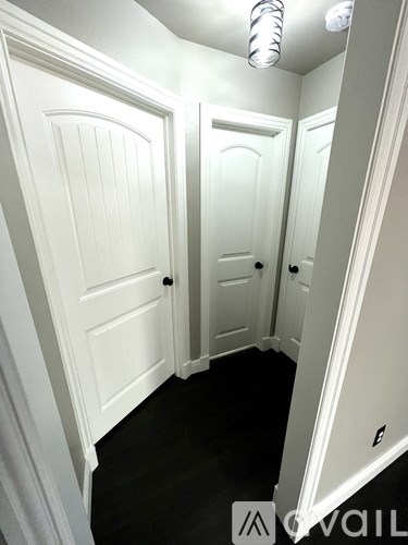 A hallway with two doors and a white ceiling.