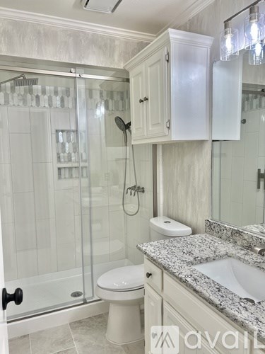 A bathroom with a toilet, sink, and shower.