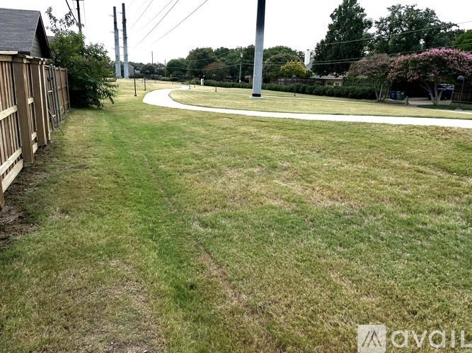 A grassy area with a path and a wooden fence.