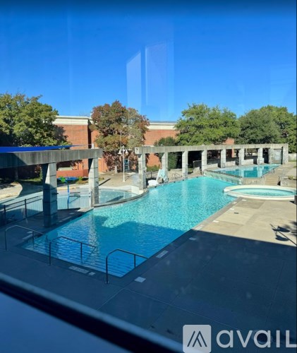 A large outdoor swimming pool with a glass wall in the foreground.