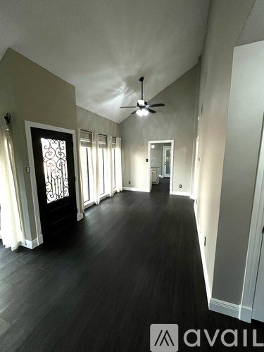 A long hallway with a fan and doors on either side.
