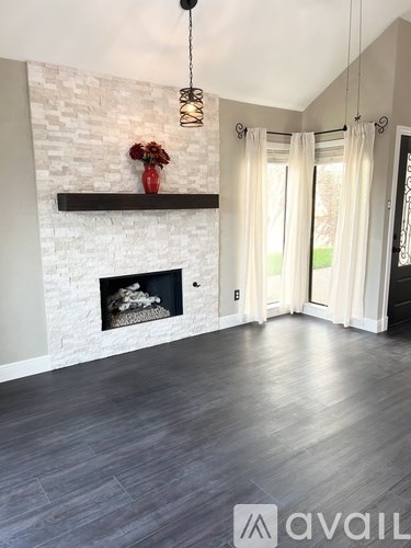 A living room with a fireplace and a vase of flowers.
