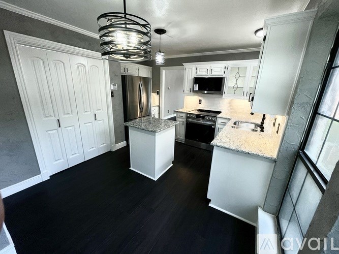 A modern kitchen with white cabinets and a central island.