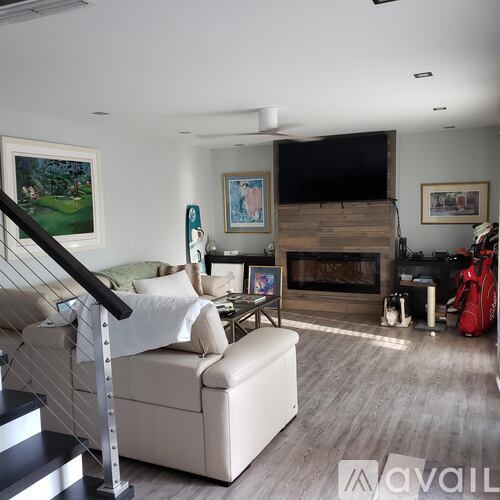 A living room with a white couch and a fireplace.