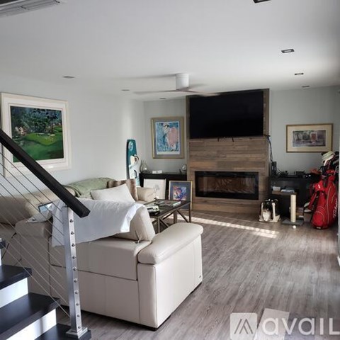 A living room with a white couch and a fireplace.