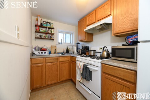 A kitchen with wooden cabinets and white appliances.