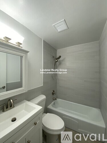 A white bathroom with a toilet, sink, and bathtub.