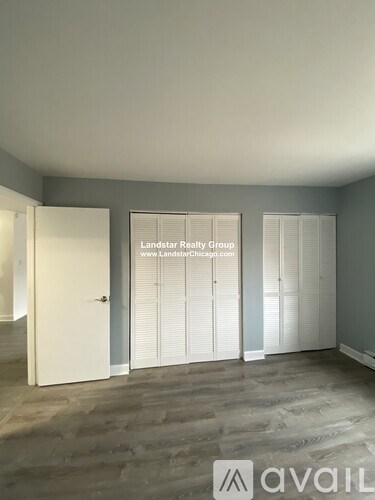 A room with a door and a window with blinds, and a sign that says "Landstar Realty Group".