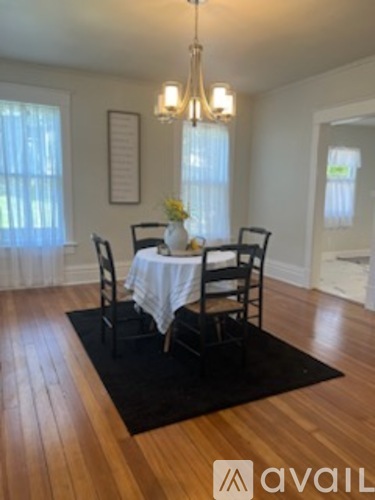 A dining room with a wooden table and chairs.