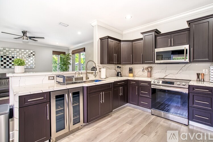 A kitchen with dark brown cabinets and stainless steel appliances.