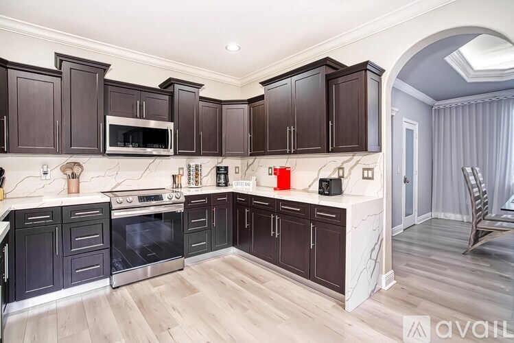 A kitchen with dark wood cabinets and a marble countertop.