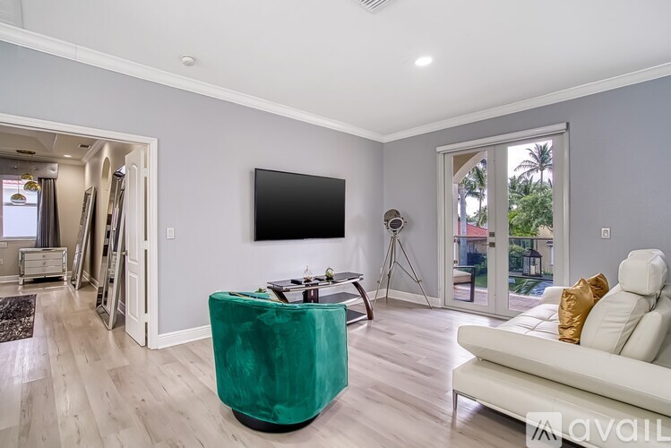A living room with a green chair and a white couch.