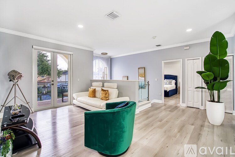 A modern living room with a green armchair and a white sofa.