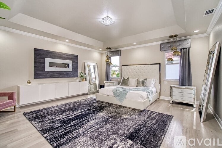 A bedroom with a large bed, a dresser, and a mirror.