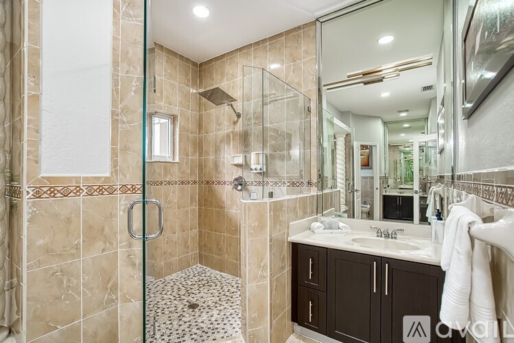 A bathroom with a walk-in shower and a sink.
