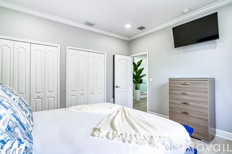 A bedroom with a bed, a dresser, and a mirror.