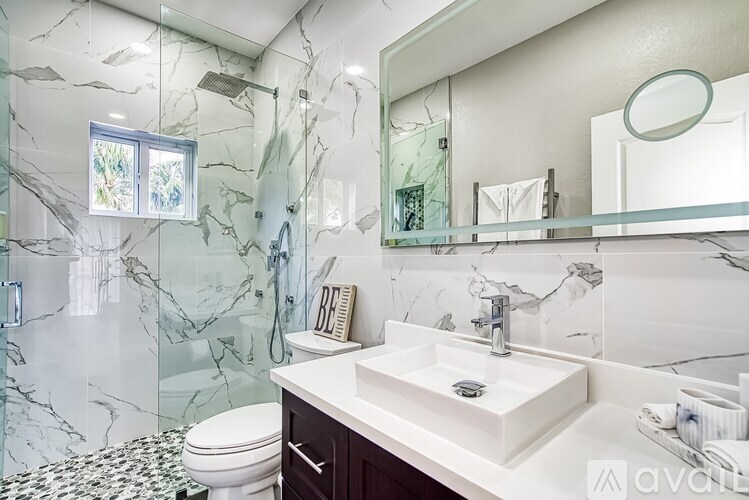 A bathroom with a marble wall and a white sink.