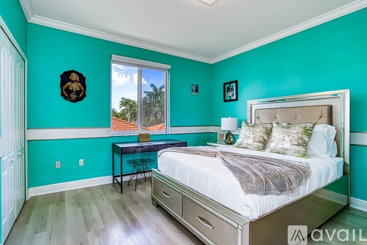 A bedroom with a bed, desk, and chair.