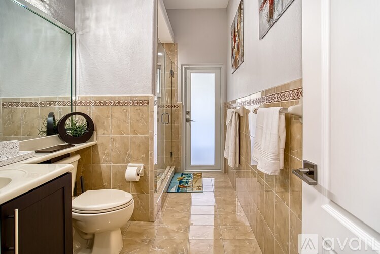 A bathroom with a toilet, sink, and shower.