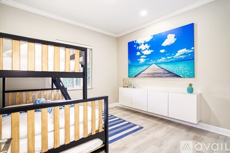 A bedroom with a large picture of a beach scene on the wall.