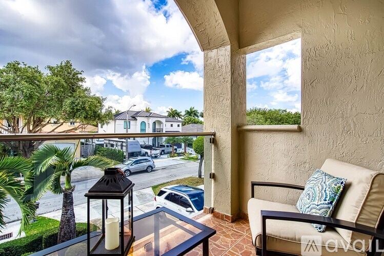 A balcony with a table and chairs overlooking a street.