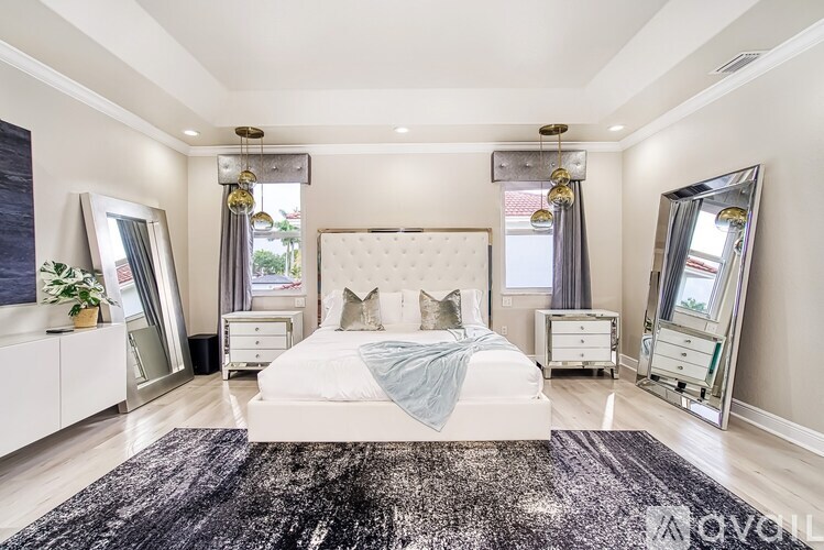 A bedroom with a large bed, a dresser, and a mirror.