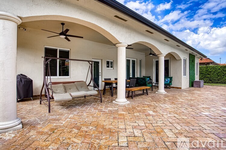 A patio with a couch, chairs, and a table.