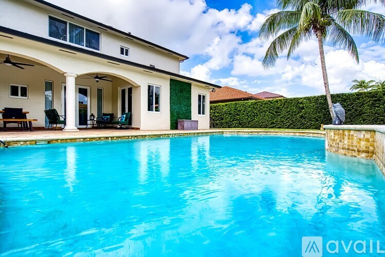 A house with a pool in front of it.