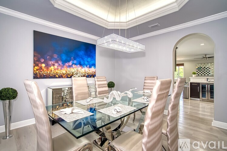 A modern dining room with a glass table and chairs.