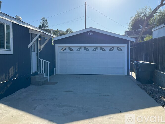 A garage with a white door is attached to a house.