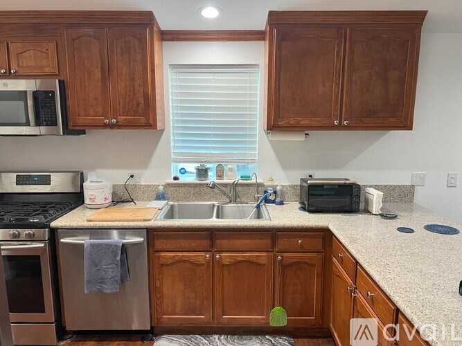 A kitchen with wooden cabinets and a stainless steel dishwasher.