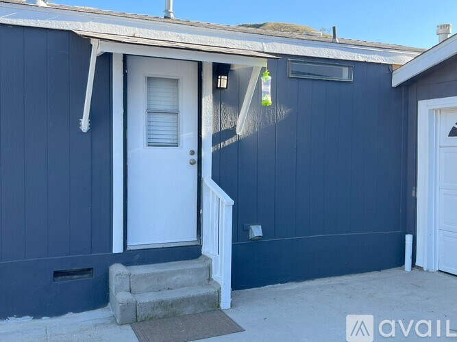 A blue house with a white door and a small porch.