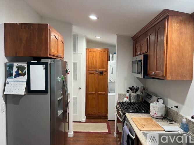 A kitchen with wooden cabinets and a fridge with a calendar on it.