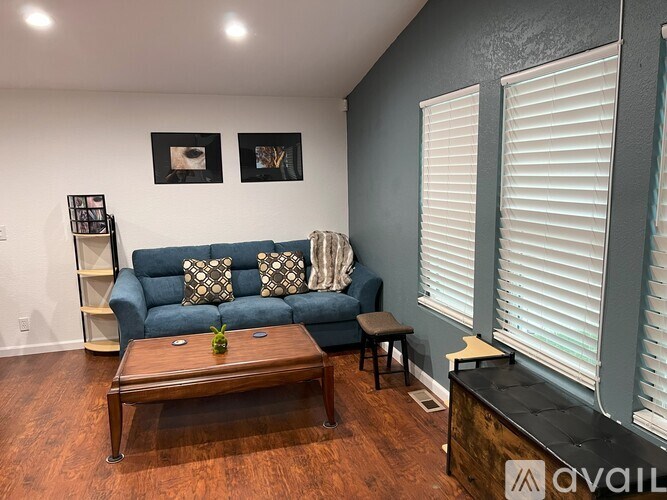 A living room with a blue couch and a wooden coffee table.