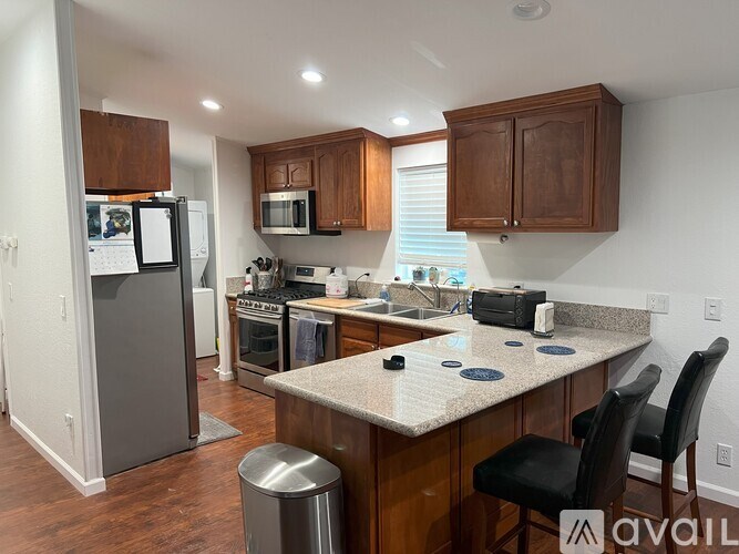 A kitchen with a granite countertop and wooden cabinets.